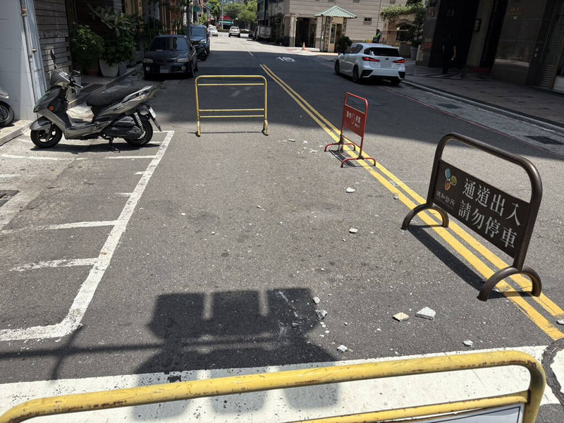 高雄市五福一路與金門街附近一棟大樓25日發生外牆磁磚掉落，造成機車騎士受傷。現場已先完成危險區域警戒及緊急處置，市府也已要求所有權人限期改善。（警方提供）中央社記者蔡孟妤傳真　115年5月25日