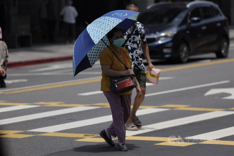 交通部中央氣象署25日發布高溫資訊，13縣市亮高溫燈號，預估26、27日氣溫將達高峰，29日鋒面南下，將帶來降溫。圖為台北市內湖區民眾撐傘外出、做好防曬。中央社記者翁睿坤攝　115年5月25日