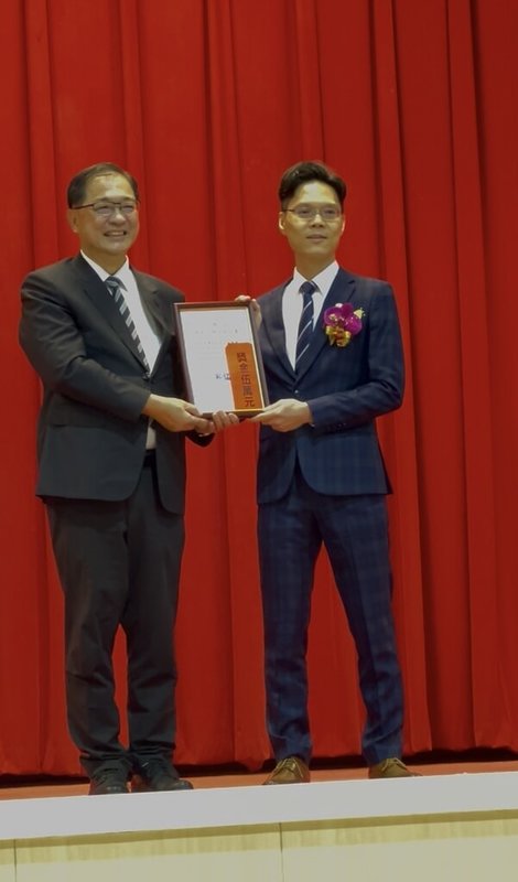法務部25日舉行115年模範公務人員頒獎典禮，新北地檢署檢察官黃佳彥（右）獲殊榮，由法務部長鄭銘謙（左）公開表揚。（新北地檢署提供）中央社記者曹亞沿傳真　115年5月25日