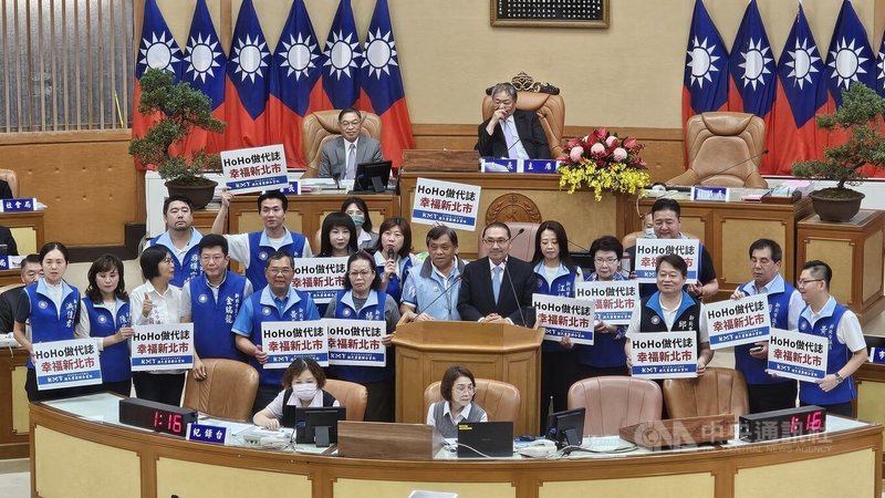 新北市議會26日進行市政總質詢，市長侯友宜（中，黑西裝者）宣布，考量鄰里長辛苦及通貨膨脹，將提高鄰里工作及聯誼活動等費用。國民黨及無黨團結聯盟議員也上台高呼「HoHo做代誌，幸福新北市」口號。中央社記者王鴻國攝　115年5月26日
