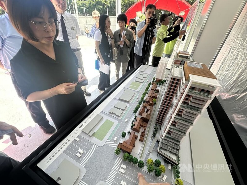 台北市都市發展局27日舉辦「金華特五」社宅開工典禮，預估2031年竣工，至於原本在基地內的歷史建築將放置原址。圖為都發局長簡瑟芳（左）在社宅模型前聆聽報告。中央社記者劉建邦攝　115年5月27日