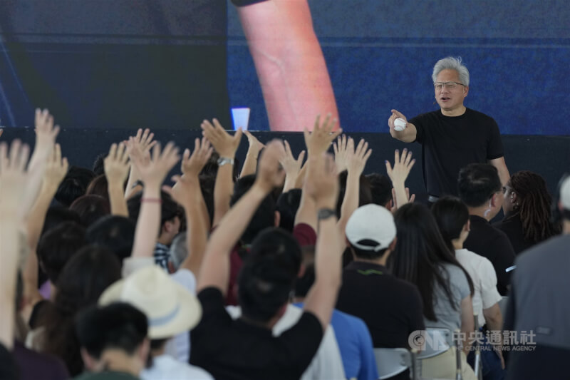 黃仁勳(右)持簽名球發送給員工。中央社記者徐肇昌攝 115年5月27日