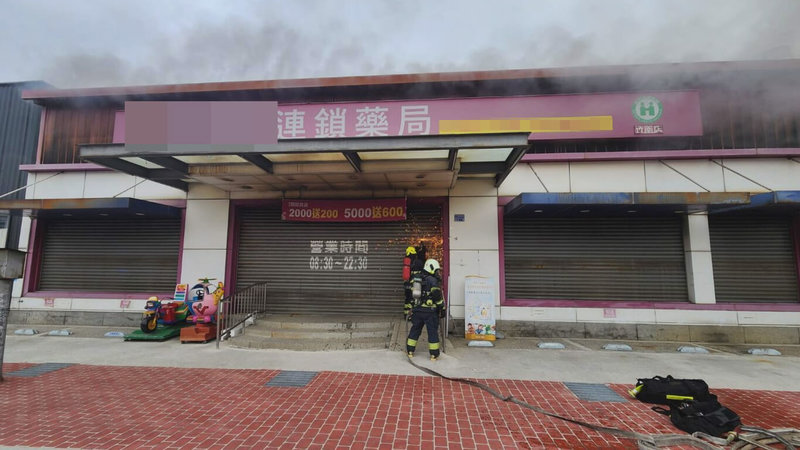 苗栗縣竹南鎮一間連鎖藥局29日清晨竄出濃煙，消防局接獲通報立即趕往搶救，不過因非營業時間大門深鎖，消防隊員利用切割器破壞鐵門，即時入內撲滅火勢。（苗栗縣消防局提供）中央社記者管瑞平傳真　115年5月29日