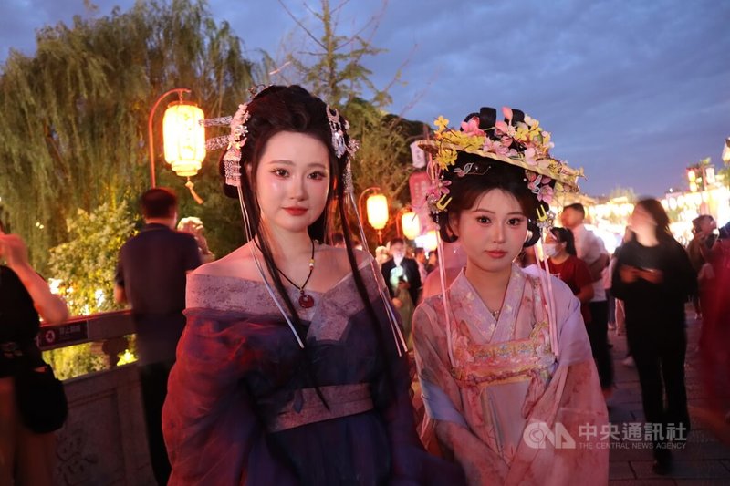 位於河南洛陽老成區的洛邑古城,許多遊客穿「漢服」到此遊逛,帶動相關產業。張小姐(左)說,自己一身行頭僅人民幣132元,包括全妝、頭飾與衣服租金,還能在一天內無限次補妝。照片攝於28日。中央社記者張淑伶洛陽攝 115年5月30日