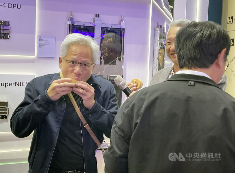 輝達（NVIDIA）執行長黃仁勳3日中午參觀鴻海COMPUTEX展區，現場大啖鴻海贈送的台灣名產紅豆餅。中央社記者鍾榮峰攝　115年6月3日