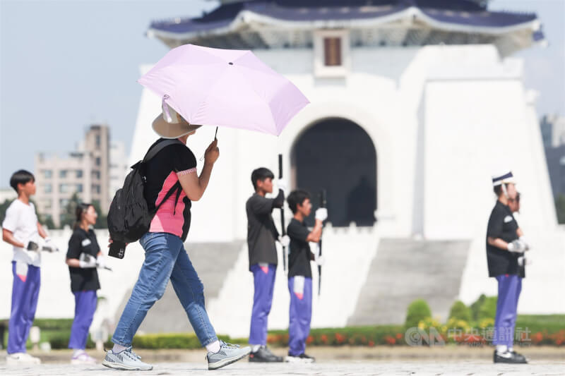 中央氣象署預報，4日西南風增強、水氣增加，中部以北上半天仍然高溫悶熱。圖為民眾撐著陽傘路過台北自由廣場。（中央社檔案照片）