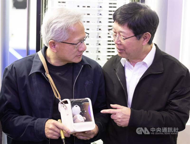 輝達執行長黃仁勳（左）3日在COMPUTEX台北南港展覽館展場參觀鴻海等供應鏈廠商展位，鴻海董事長劉揚偉（右）贈送黃仁勳AI陪伴機器人－「Poketomo 口袋同萌」。中央社記者趙世勳攝 115年6月3日