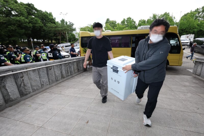 韓國警方5日上午將首爾蠶室7洞第2投票所投票箱送到計票站。（韓聯社）