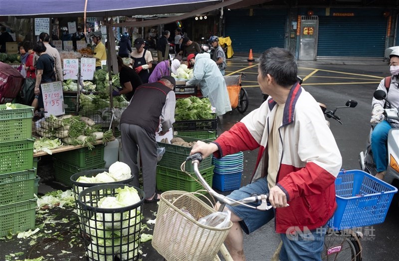 圖為新北市板橋區民眾駐足觀看一處攤位的菜價。（中央社檔案照片）