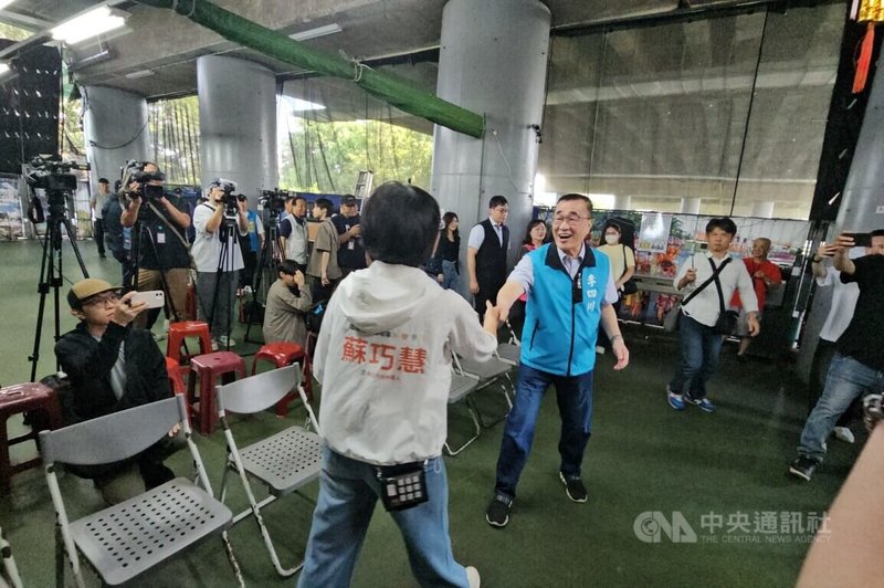 國民黨新北市長參選人李四川(前右)、民進黨新北市長參選人蘇巧慧(背對者)上午到永和拜票,兩人相互握手問好,展現君子之爭的好風度。中央社記者王鴻國攝 115年6月7日