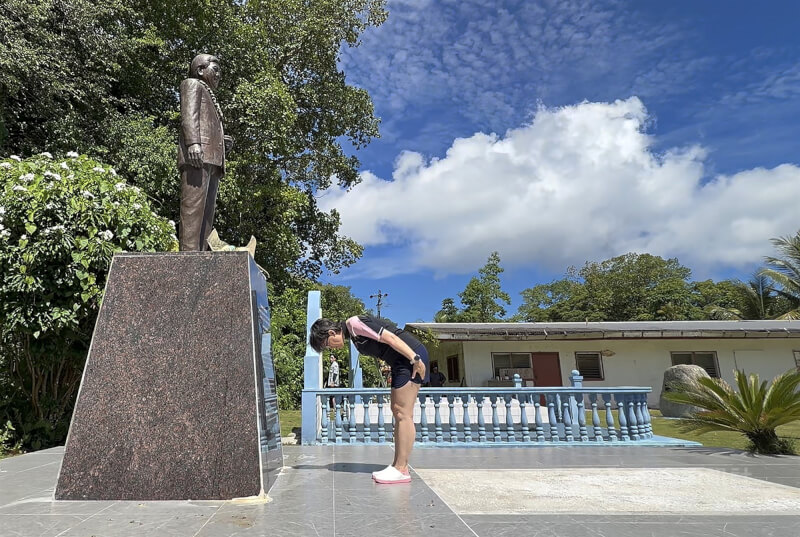 副總統蕭美琴（前）7日前往帛琉前總統中村國雄墓園，在雕像前鞠躬致意。中央社記者裴禛貝里琉州攝　115年6月7日