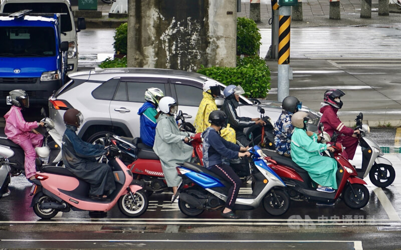 圖為高雄市前鎮區8日午後出現雨勢，機車騎士紛紛穿起雨衣。中央社記者董俊志攝　115年6月8日