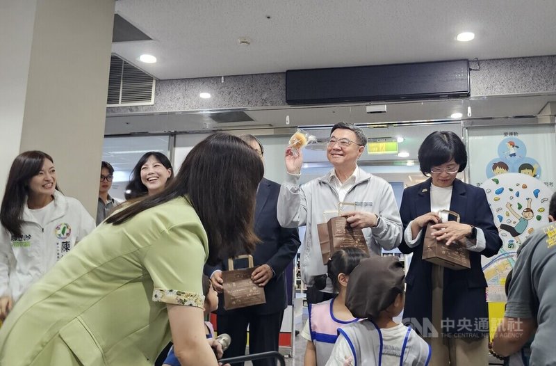 行政院長卓榮泰(立者右2)9日訪視位於新北市的行政院新莊聯合辦公大樓各進駐機關員工子女非營利幼兒園,開心收下小朋友送的手作麵包。中央社記者王鴻國攝 115年6月9日