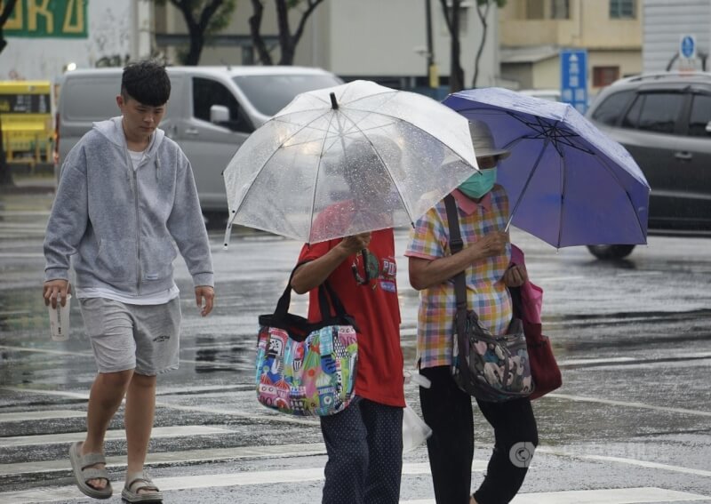 圖為高雄市新興區撐傘過馬路的民眾。（中央社檔案照片）