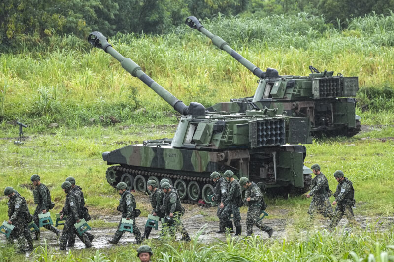 任務結束後,官兵攜帶裝備離開射擊陣地,後方為M109A2自走砲。中央社記者鄭清元攝 115年6月9日