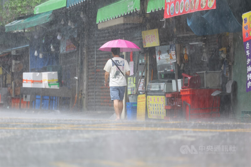 圖為台北市內湖區民眾8日在大雨中撐傘前行。(中央社檔案照片)