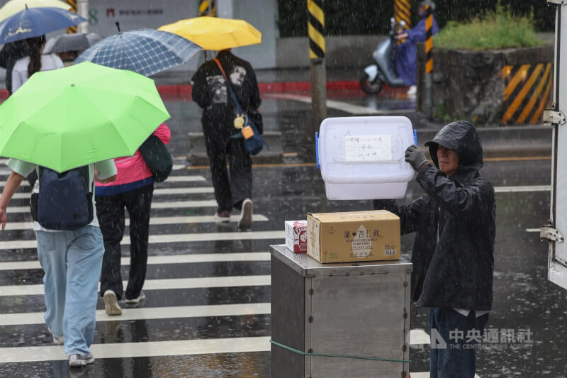 圖為台北市中山區民眾穿著雨衣工作。（中央社檔案照片）