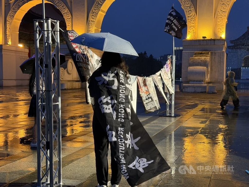 在台港人、香港邊城青年與台灣民間團體，12日晚間於自由廣場舉行「612行動－恆裏如已，礪行如始」紀念活動。圖為台灣民眾披著寫上「光復香港、時代革命」的披風與會。中央社記者呂佳蓉攝　115年6月12日