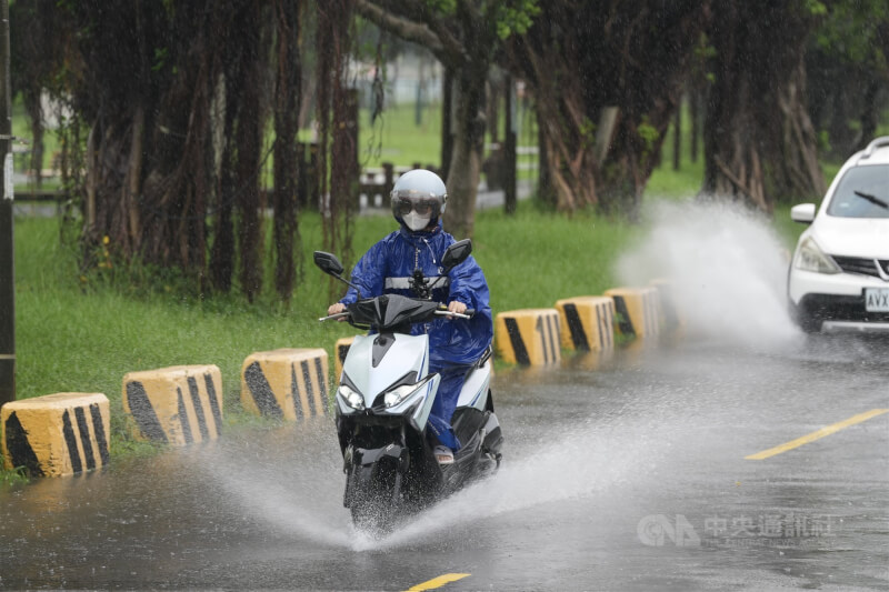 圖為民眾在台北市士林區的堤防外行經積水路段，激起水花。（中央社檔案照片）
