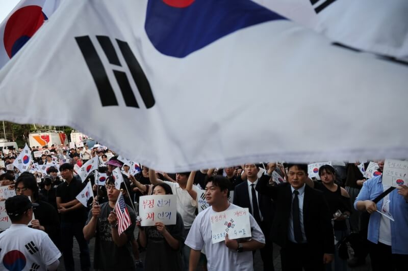 韓國近日發生地方選舉選票不足事件，引發民眾抗議。圖為抗議民眾10日在首爾計票中心前高喊口號，要求重新舉行地方選舉。（路透社）