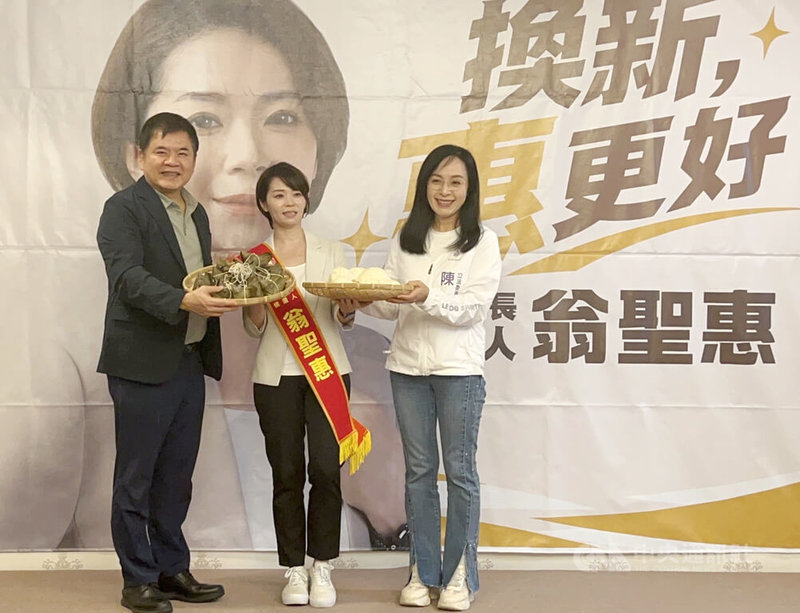 民進黨台東縣黨部13日宣布徵召縣黨部執行長翁聖惠 (中)參選台東市長,黨籍立委陳瑩(右)、莊瑞雄 (左)分別送上包子與粽子,象徵「包中」。中央社記者盧太城攝 115年6月13日
