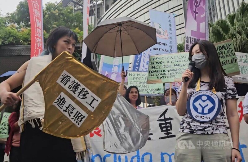 共同行動團體14日在衛福部前演出行動劇，指湖中女神「衛福部」（左）藏起象徵「機構聘僱家事移工」的金斧頭，任由公共長照議題淪為雇主與移工的勞資糾紛與弱弱相殘。中央社記者陳婕翎攝 115年6月14日