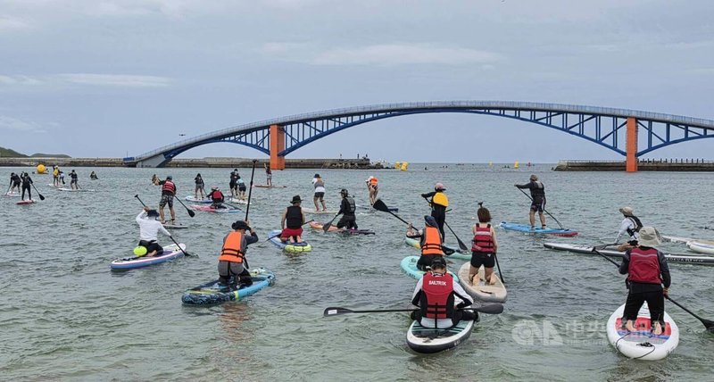 「2026 PENGHU OCEANMAN 國際泳渡澎湖灣」，14日受天候影響，泳渡組5公里改由觀音亭海域下水挑戰，立式划槳5公里在湧浪海潮中挺進。中央社  115年6月14日