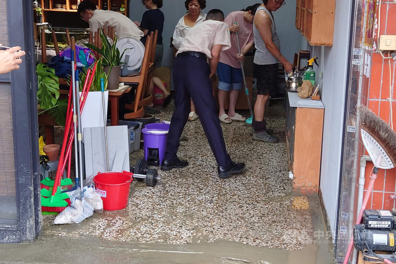 台南市仁德區中正路一處路面15日疑似因自來水管線破裂，地基掏空造成坑洞，泥水一度流入一旁民宅，住戶忙著清理善後。中央社記者楊思瑞攝　115年6月15日