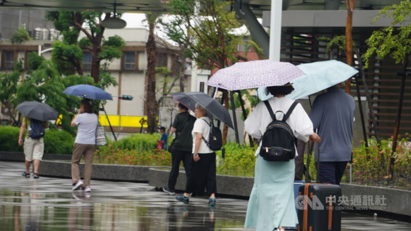 圖為高雄市三民區路上行人撐傘遮擋雨勢。中央社記者董俊志攝　115年6月16日