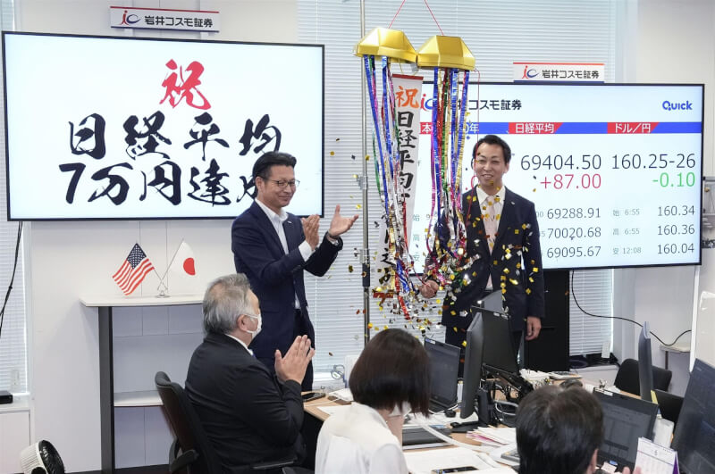 日經平均指數連續第4個交易日上漲，16日盤中首度突破7萬點大關，創下歷史新紀錄。圖為券商在盤後慶祝紅盤成績。（共同社）