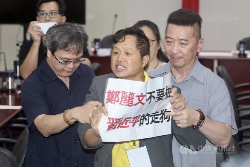 獨派團體台灣國理事長陳峻涵(中)17日以公民記者名義,手持標語「鄭麗文不要做習近平走狗」,進入國民黨主席鄭麗文赴美返台記者會抗議。中央社記者王飛華攝 115年6月17日