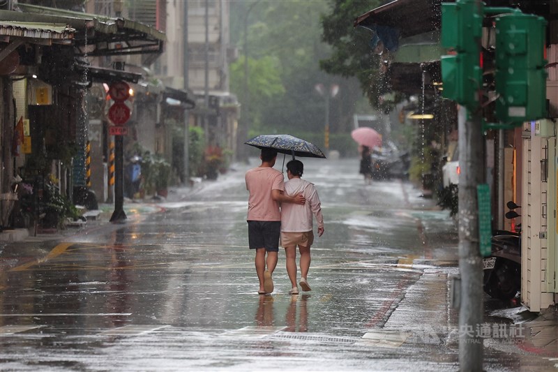 圖為台北市內湖區下午下起傾盆大雨，民眾2人共撐一把傘。（中央社檔案照片）