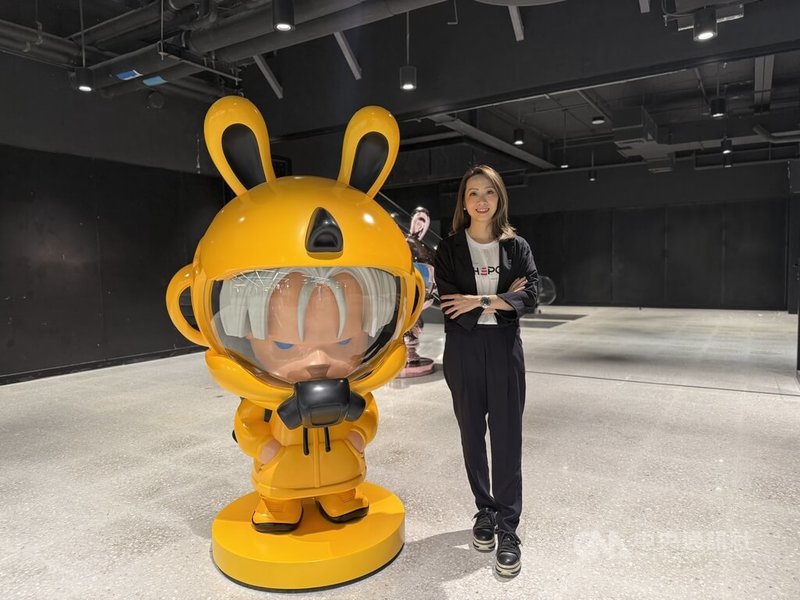 曼谷當代藝術策展公司(BCAF)執行長楊晴莉18日在泰國首屆國際創意與IP藝術展「THΞPOP 2026」展區與大型角色雕塑合影。中央社記者李宗憲曼谷攝 115年6月18日