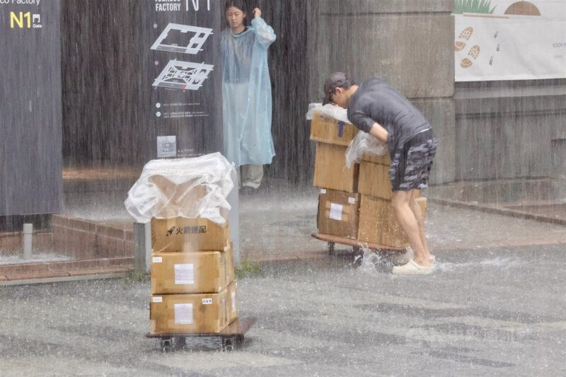 中央氣象署18日發布豪雨特報，台北市區午後出現強降雨，松山區一名快遞員在大雨中辛苦送貨。中央社記者王飛華攝　115年6月18日