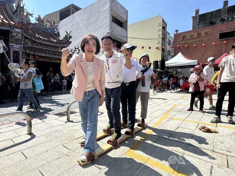 民進黨立委、台中市長參選人何欣純(前左)19日端午節現身台中市南屯區端午節慶活動「穿木屐躦鯪鯉」,現場挑戰4人協力木屐,體驗傳統文化。中央社記者趙麗妍攝 115年6月19日