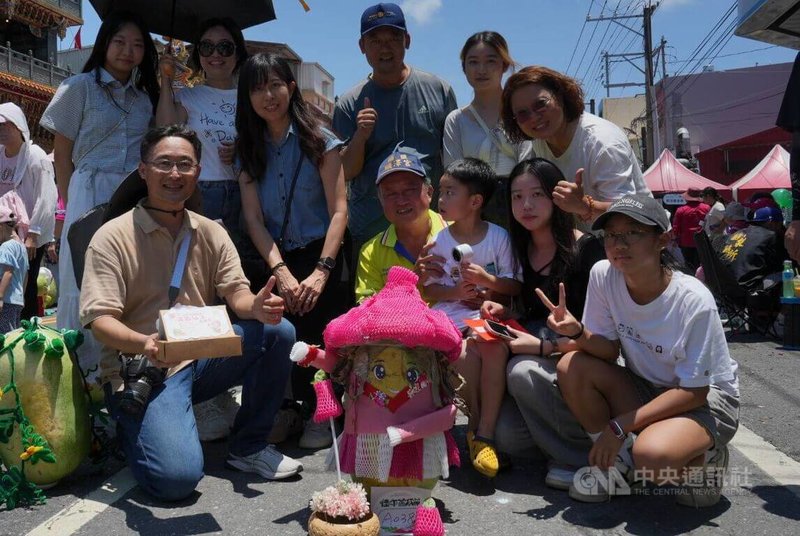 屏東縣佳冬鄉立西瓜活動首辦造型賽,奪冠參賽者黃瓊貞(2排左3)說,她將主題訂為「佳冬守護精靈-蓮霧仙子來報喜」,並利用水果網套等免費包材再利用。中央社記者黃郁菁攝 115年6月19日