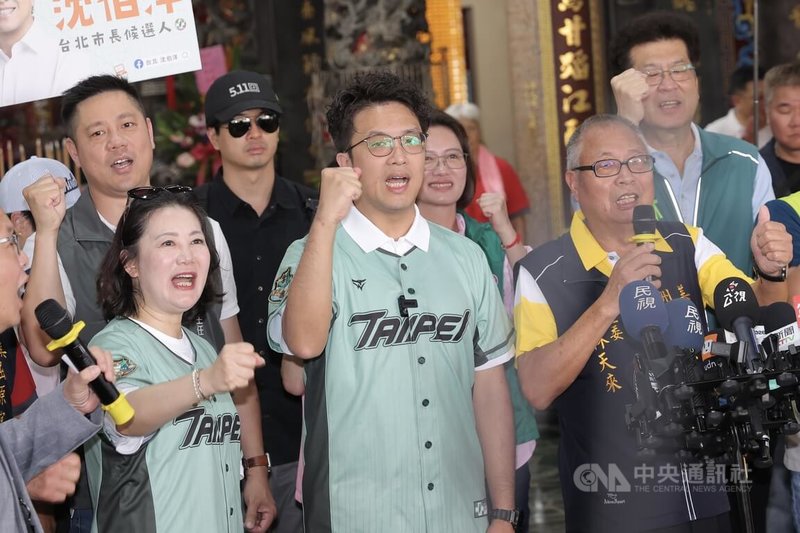 民進黨台北市長參選人沈伯洋(前中)19日上午出席屈原宮龍舟競渡,會前接受媒體聯訪回應北市下大雨積水等議題,並喊振臂高呼「凍蒜」口號。中央社記者翁睿坤攝 115年6月19日