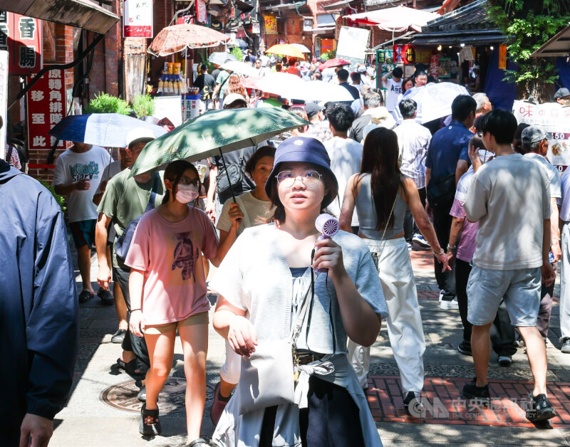 圖為新北市深坑老街逛街民眾手持小風扇降溫消暑。中央社記者謝佳璋攝  115年6月21日