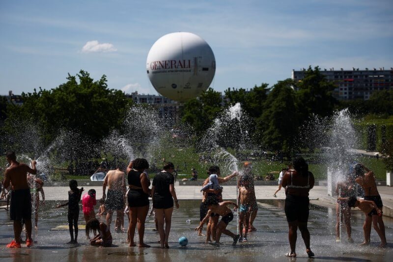 熱浪21日席捲法國部分地區，民眾在巴黎一處公園的噴泉嬉戲。（路透社）