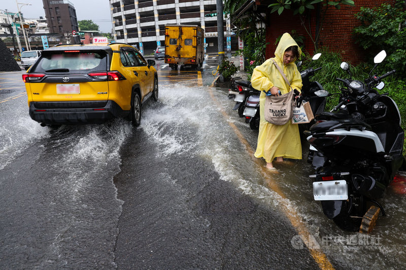氣象署25日上午發布豪雨特報，颱風米克拉北上，鋒面接近及西南風增強影響，易有短延時強降雨，雙北防豪雨，新北市淡水區發生積淹水情形，機車騎士將車輛停放在路旁。中央社記者吳家昇攝　115年6月25日