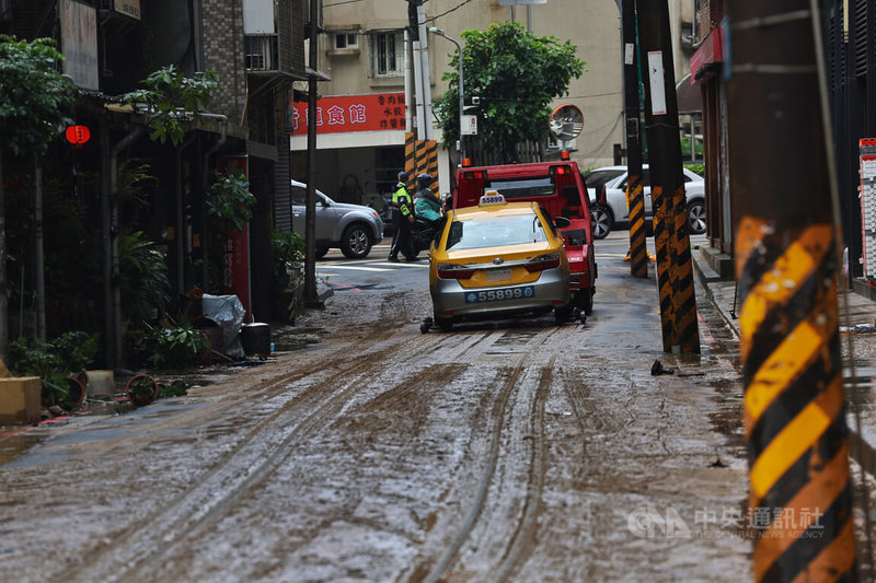 颱風米克拉及西南風增強帶來劇烈降雨，台北市內湖區25日上午傳出積淹水災情，積水退去後街道仍滿是泥濘，拖吊車將拋錨車輛拖離。中央社記者王飛華攝　115年6月25日