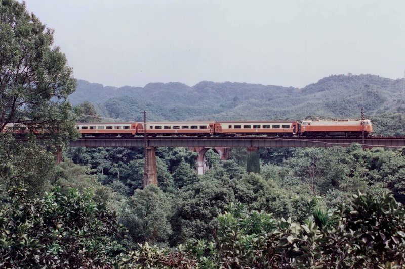 台鐵表示，莒光號最輝煌時期全線最多曾開行76列次。圖為1993年9月間電力機車牽引莒光號行駛在改線前的山線勝興至泰安之間的魚藤坪鐵橋，背景可見龍騰斷橋。（鄭銘彰提供）中央社記者黃巧雯傳真　115年6月27日