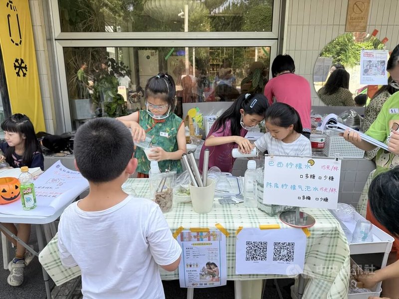 上海長寧區的「新華社區」假日舉辦兒童市集，在大人指導下，由兒童調製飲料、接待顧客。中央社記者廖文綺上海攝　115年6月28日