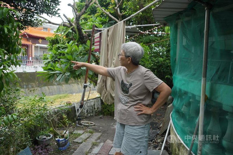 屏東潮州鎮0625豪雨淹水受災戶、住家緊鄰柳枝溝的光輪路溫姓居民（圖）認為，光輪路對向堤岸高出許多，希望政府重新整治並加高住家這側堤岸。中央社記者黃郁菁攝　115年6月28日
