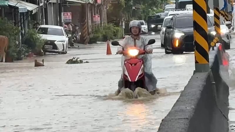 圖為25日高雄市旗山區路面積淹水，騎士經過激起水花。（翻攝照片）中央社記者董俊志傳真