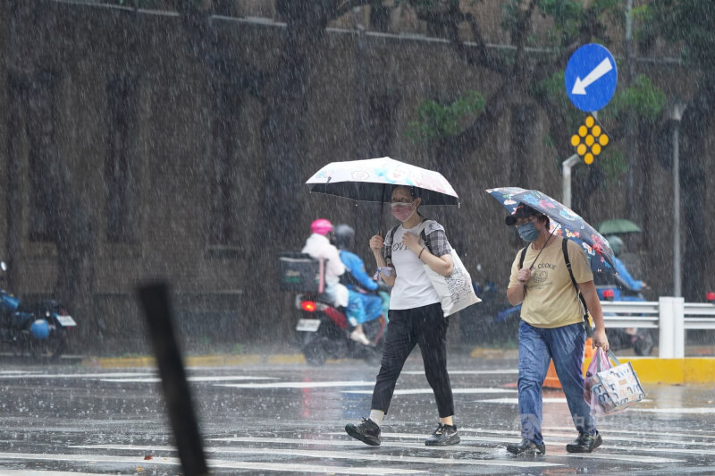 台北市中正區街頭民眾撐傘避雨。（中央社檔案照片）