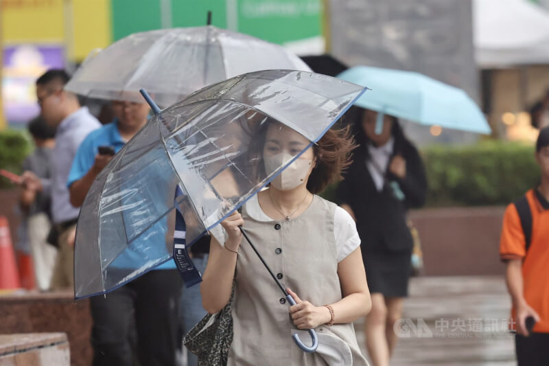 圖為台北街頭民眾撐傘遮擋雨勢。（中央社檔案照片）