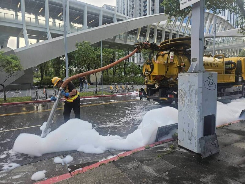 台灣高鐵南港站泡沫設備29日不明原因放射並溢流至周邊路面，台北市環保局調派沖洗溝泥車、洗街車清理，後續確認沒有環境污染疑慮，並依違反廢棄物清理法開罰。（台北市環保局提供）中央社記者陳昱婷傳真　115年6月30日