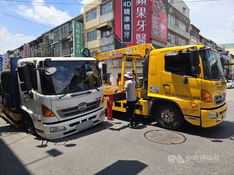 一輛大貨車2日上午於屏東市廣東路前陷天坑,屏東市公所獲報緊急請拖吊車將貨車吊出來。中央社記者黃郁菁攝 115年7月2日