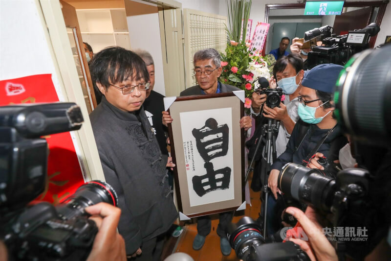 銅鑼灣書店2020年4月25日在台北重新開幕,創辦人林榮基(中)表示,希望有更多香港朋友能到訪。華人民主書院與六四學生領袖王丹共同致贈社運人士何宗勳書法作品「自由」。(中央社檔案照片)
